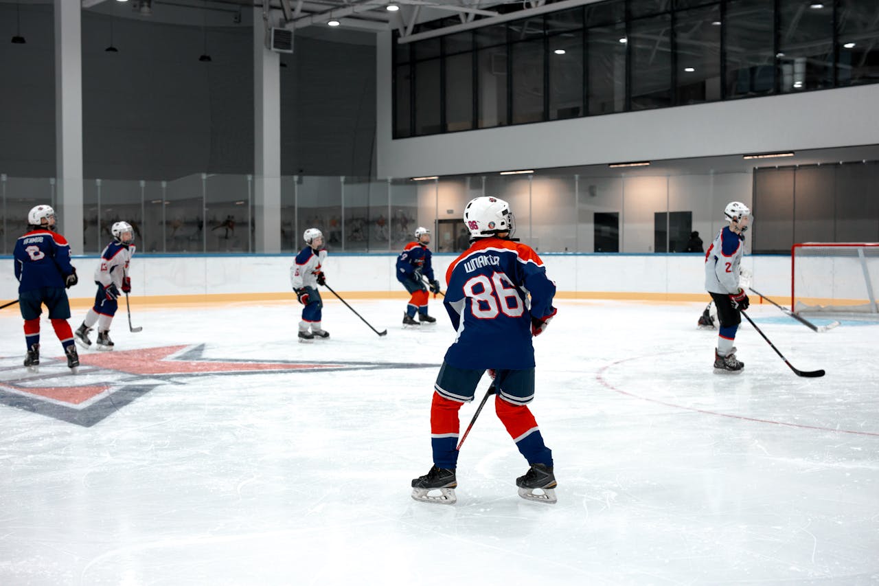 Action shot of a youth ice hockey game in an indoor rink, highlighting team sportsmanship.